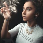 Woman in a modern setting interacting with a holographic user interface. Futuristic concept.
